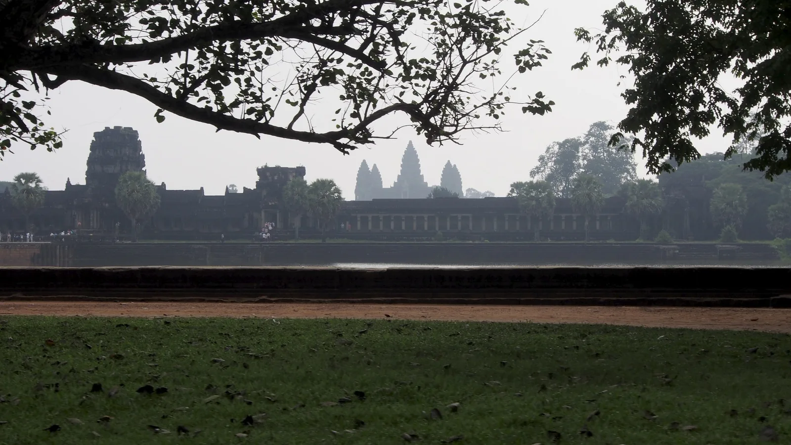 The towers of Angkor Wat rise across a moat in hazy morning light near Siem Reap.