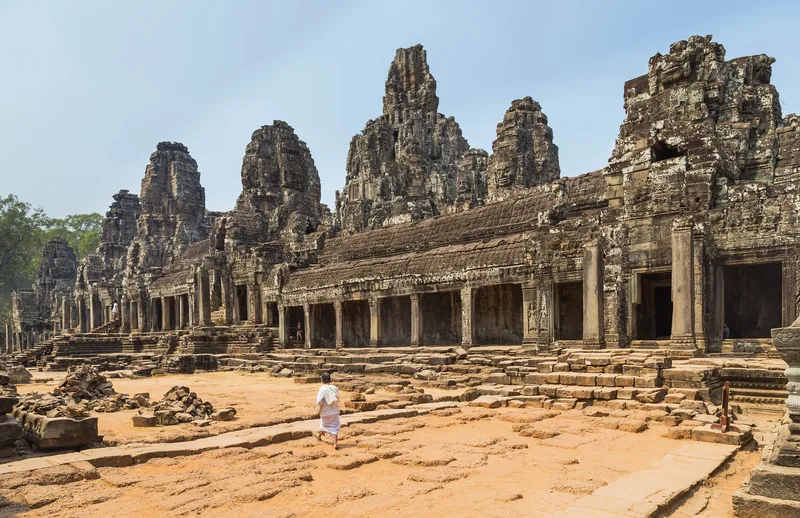 Stone towers carved with faces rise above the ancient galleries of Bayon temple in Angkor Thom, Siem Reap.