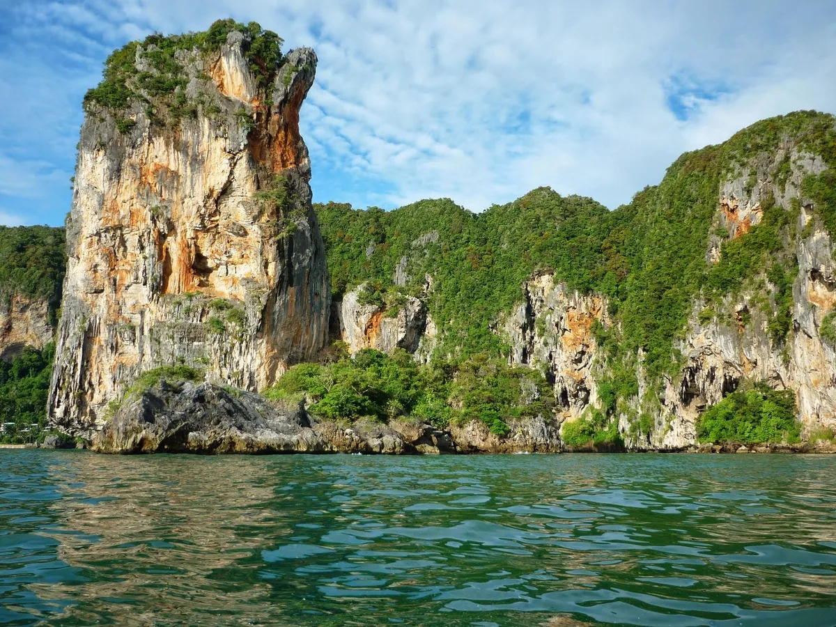Towering limestone karsts rise from turquoise sea waters near Railay Bay in Krabi, Thailand.