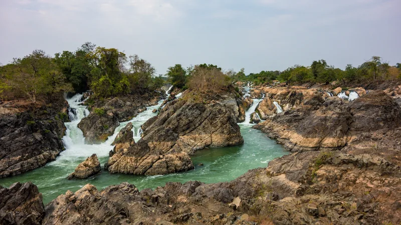 Rocky river channels and cascading waterfalls cut through the islands of Si Phan Don in Laos.