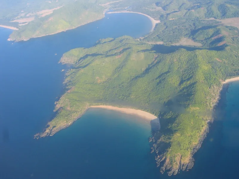 Aerial view of forested peninsulas and coves along the Palawan coastline in the Philippines.
