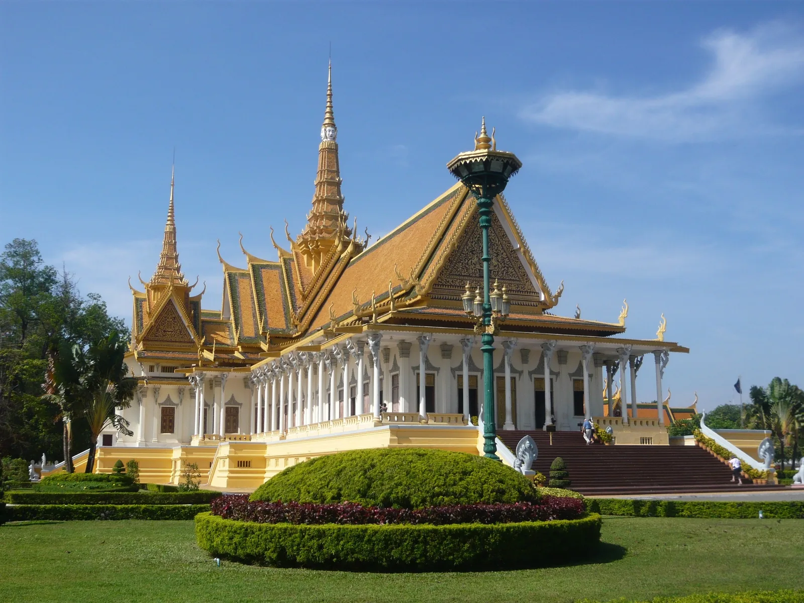 The gilded spires and columned hall of the Royal Palace rise above manicured gardens in Phnom Penh.