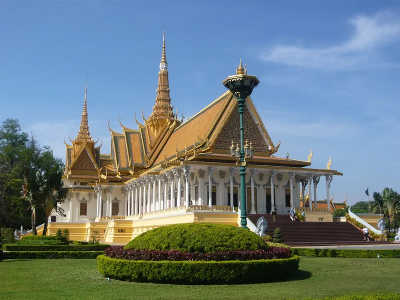 The gilded spires and columned hall of the Royal Palace rise above manicured gardens in Phnom Penh.