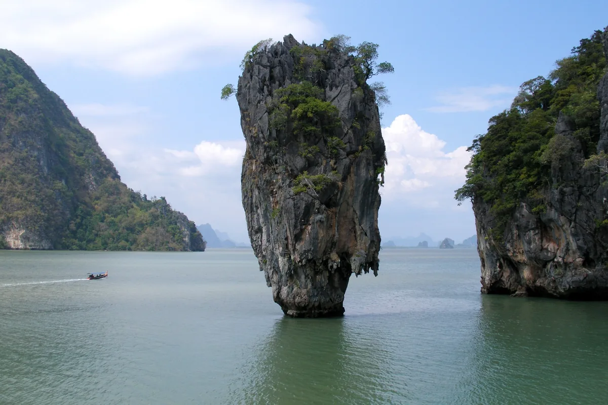 A tall limestone rock pinnacle rises from the sea at Ko Tapu, James Bond Island, in Phang Nga Bay.