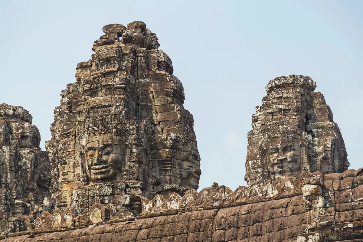 Stone towers carved with serene smiling faces rise at Bayon Temple in Angkor Thom, Siem Reap.