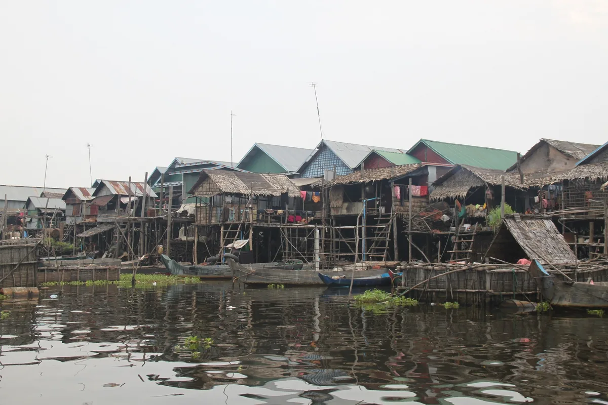 Stilt houses with wooden boats line the water at a floating village on Tonle Sap Lake near Siem Reap.