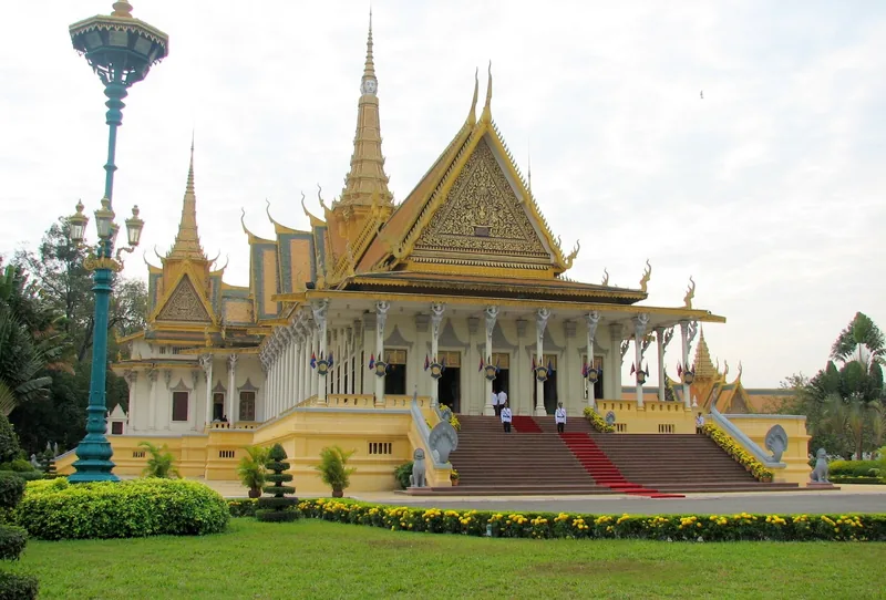 The golden spires and throne hall of the Royal Palace rise above manicured gardens in Phnom Penh.