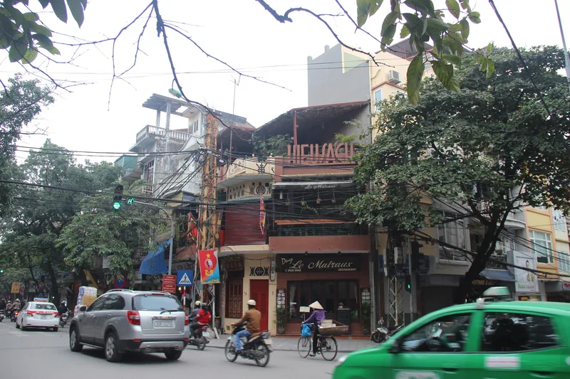 Traffic and old buildings line Hang Gai street in Hanoi's Old Quarter.
