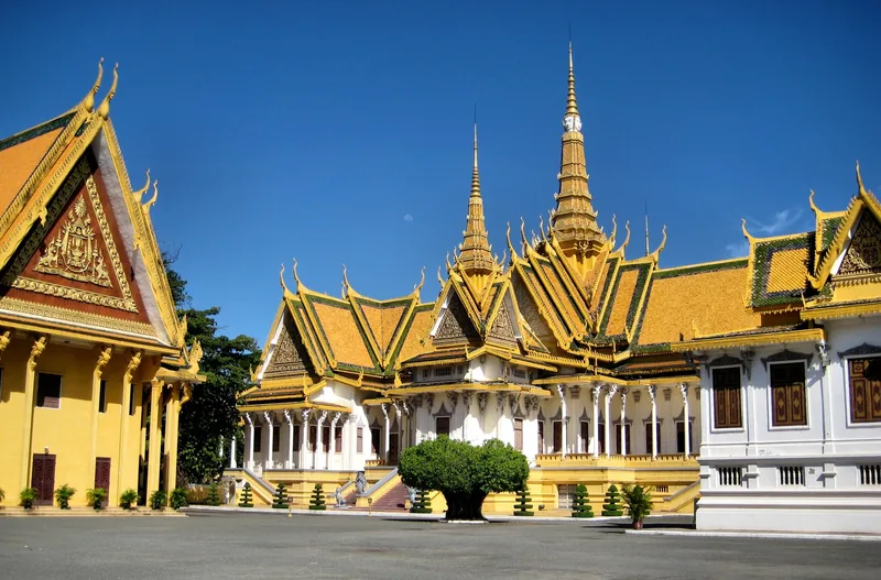 Golden spires and ornate roofs crown the Royal Palace complex in Phnom Penh under a clear blue sky.