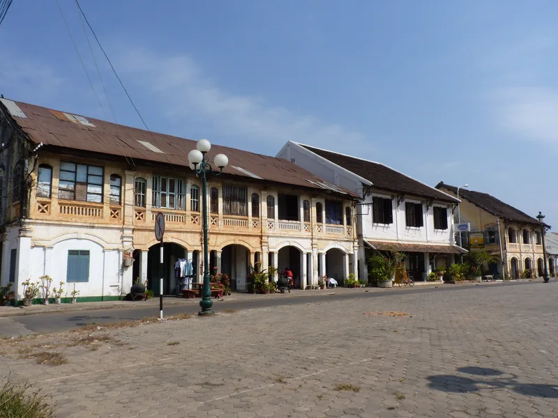 Colonial-era shophouses line a quiet cobblestone square in Savannakhet's old town.
